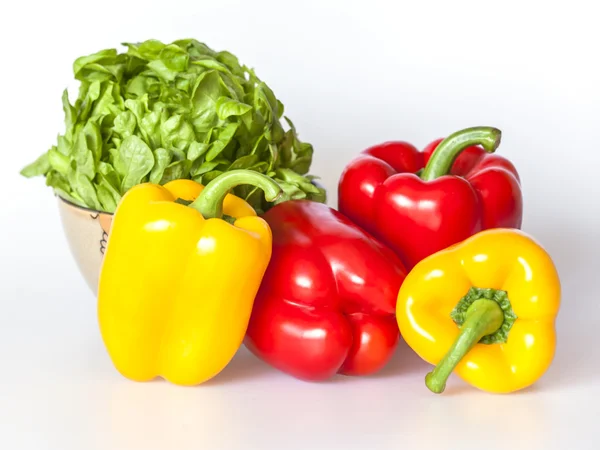 Large red and yellow paprikas and bunch of fresh salad Stock Picture
