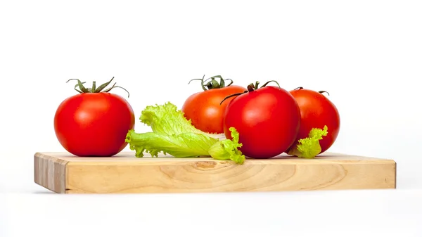 Rote saftige Tomaten und Salatblätter — Stockfoto