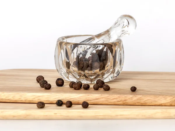 Black pepper in a transparent mortar with a pestle — Stock Photo, Image