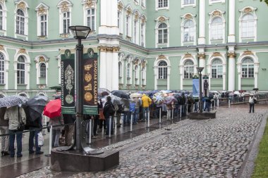 St Petersburg, Rusya, 24 Temmuz 2012 tarihinde. Turistler ve vatandaşların devlet Hermitage Müzesi'almak için bir sıra yağmurda stand. Hermitage - dünyanın en ünlü sanat müzeleri