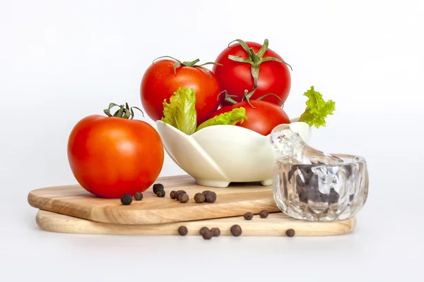 Красные сочные помидоры, листья салата и черный перец — стоковое фото