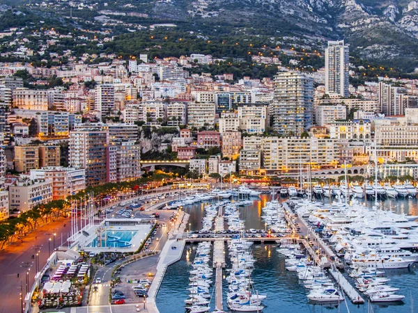 Principado de Mónaco, Francia, el 16 de octubre de 2012. Una vista del puerto y las zonas residenciales en una ladera de montañas al atardecer — Foto de Stock