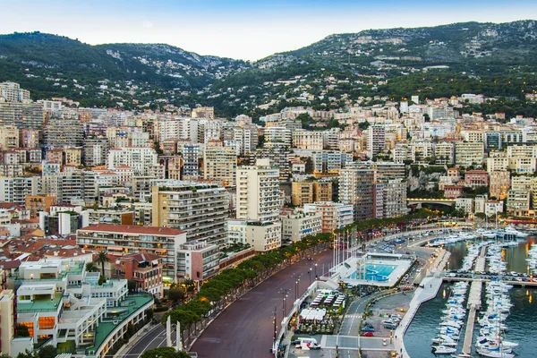 Principado de Mónaco, Francia, el 16 de octubre de 2012. Una vista del puerto y las zonas residenciales en una ladera de montañas al atardecer — Foto de Stock