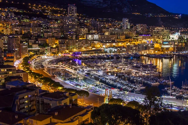 Principado de Mónaco, Francia, el 16 de octubre de 2012. Una vista nocturna del puerto y zonas residenciales en una ladera de montañas — Foto de Stock