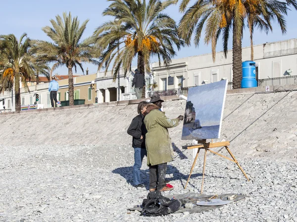 Nice, Frankrijk, op 14 maart 2015. De kunstenaar schetst een beeld op een strand in de lente middag — Stockfoto