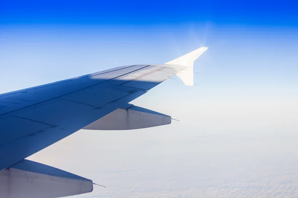 Blick auf einen Flügel des Flugzeugs und die Wolke aus einem Fenster des fliegenden Flugzeugs — Stockfoto