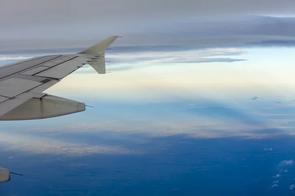 Blick auf einen Flügel des Flugzeugs und die Wolke aus einem Fenster des fliegenden Flugzeugs — Stockfoto