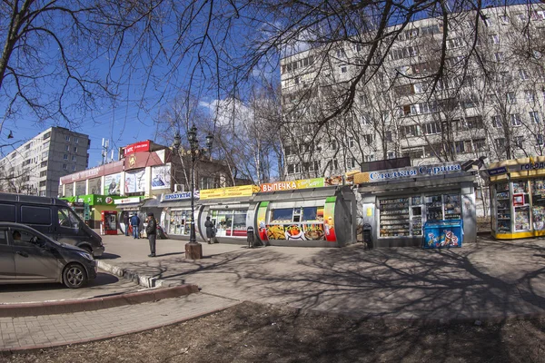 Pushkino, Rússia, em 10 de abril de 2015. Cabines da imprensa e fast food na avenida . — Fotografia de Stock