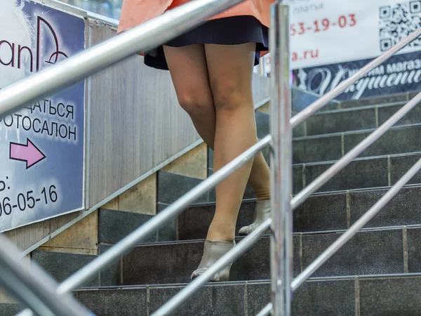 Pushkino, Rusia, 12 de abril de 2015. Los pies de la mujer que sube a la escalera en el centro comercial —  Fotos de Stock