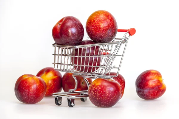 Large red plums in the store cart — Stock Photo, Image