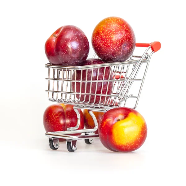 Large red plums in the store cart — Stock Photo, Image