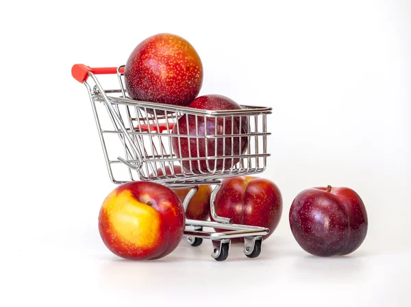 Large red plums in the store cart — Stock Photo, Image