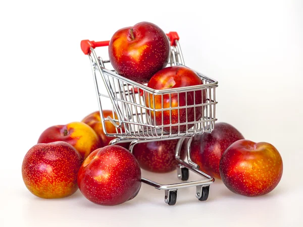 Large red plums in the store cart — Stock Photo, Image