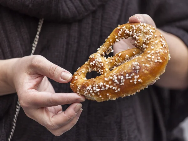 The woman holds an appetizing roll in hand — Stock Photo, Image