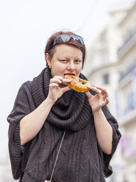 Nice, França, em 10 de março de 2015. A mulher come um rolo apetitoso na rua — Fotografia de Stock