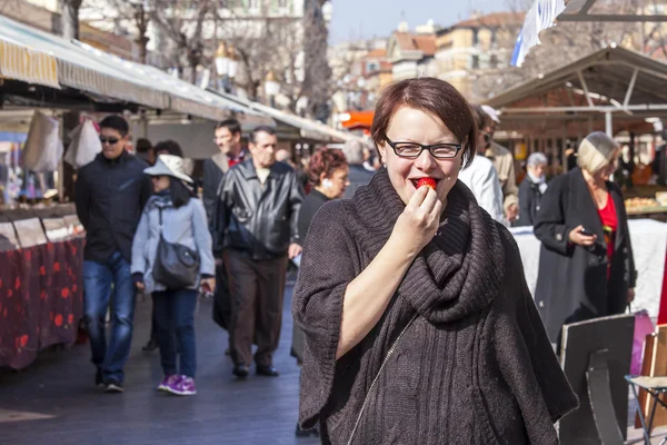 Ніцца, Франція, на 11 березня 2015 року. Жінка на ринку на смак свіжої полуниці — стокове фото