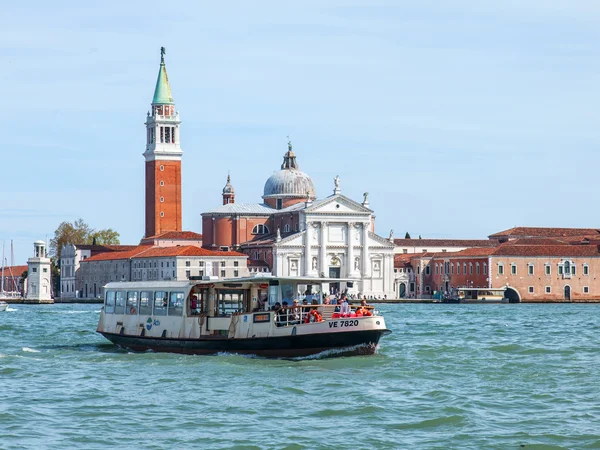 Venice, Italië - op 29 April 2015. Vaporetto met passagiers drijft op de Venetiaanse lagune. San Giorgio van eiland in de verte. — Stockfoto