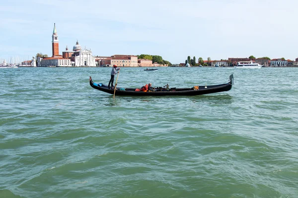 VENEZIA - il 29 APRILE 2015. La gondola con i passeggeri galleggia sulla laguna veneziana. Isola di San Giorgio in lontananza . — Foto Stock