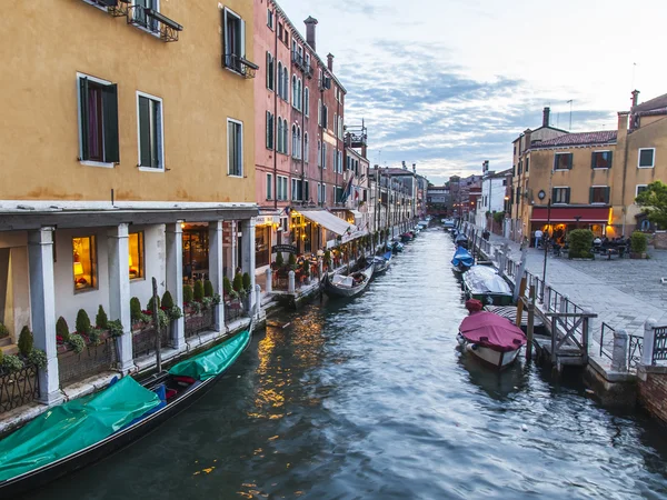 VENICE, ITALY - on APRIL 29, 2015. Typical urban view in the evening. Street canal and ancient buildings ashore — Stock Photo, Image