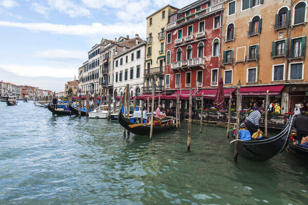 VENICE, ITALY - on APRIL 30, 2015. Typical urban view. The coast of the Grand channel (Canal Grande), the house on the coast and gondolas. The grand channel is the main transport artery of Venice and its most known channel