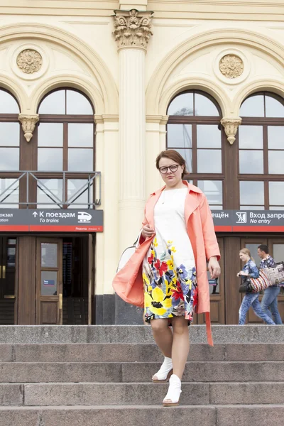 MOSCÚ, RUSIA, 24 DE MAYO DE 2015. La mujer con un impermeable brillante abandona el edificio de la estación de Leningrado —  Fotos de Stock