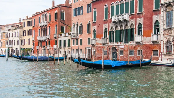 VENICE, ITALIA - 30. huhtikuuta 2015. Tyypillinen kaupunkinäkymä. Rannikko Grand kanava (Canal Grande), talo rannikolla ja gondolit. Suuri kanava on tärkein liikenneväylä Venetsian ja sen tunnetuin kanava — kuvapankkivalokuva