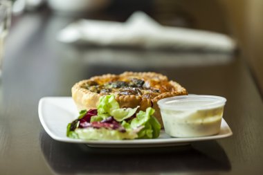 Fransız mutfağı: açık Quiche pasta servis sos ve yeşillik bir plaka üzerinde