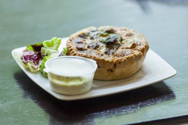 Fransız mutfağı: açık Quiche pasta servis sos ve yeşillik bir plaka üzerinde