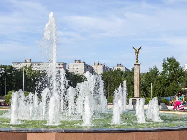 PUSHKINO, RUSIA - el 10 de junio de 2015. Paisaje urbano en la tarde de primavera. Un monumento en el centro de la ciudad y edificios nuevos de varios pisos —  Fotos de Stock