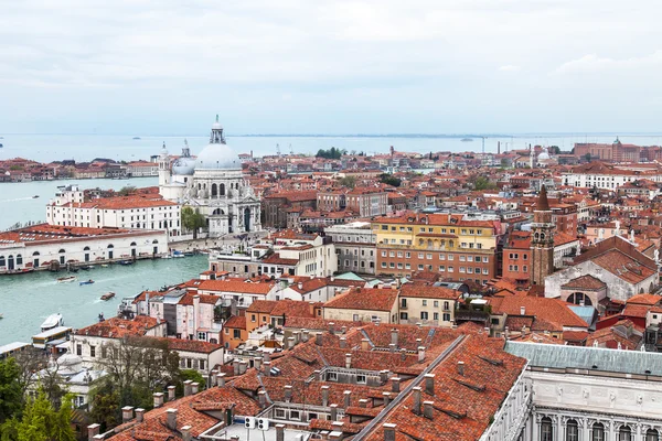 Venedig, Italien - den 30 April 2015. Ovanifrån från San Marco kampanilla på domkyrkan Santa Maria della Salute (Basilica di Santa Maria della Salute) och ett tak av antika palats — Stockfoto