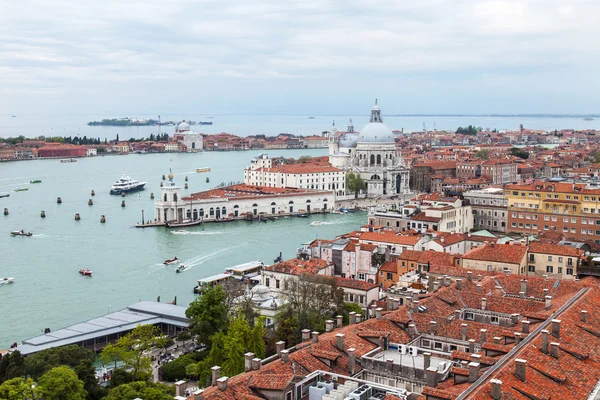 Venedig, Italien - den 30 April 2015. Ovanifrån från San Marco kampanilla på domkyrkan Santa Maria della Salute (Basilica di Santa Maria della Salute) och ett tak av antika palats — Stockfoto