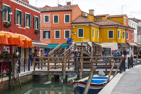 Venedig, Italien, den 30 April 2015. Ön Burano, multi-färgade husen av lokalbefolkningen. Bridge via kanal. Burano ön - en av attraktiv turist objekt i den venetianska lagunen — Stockfoto