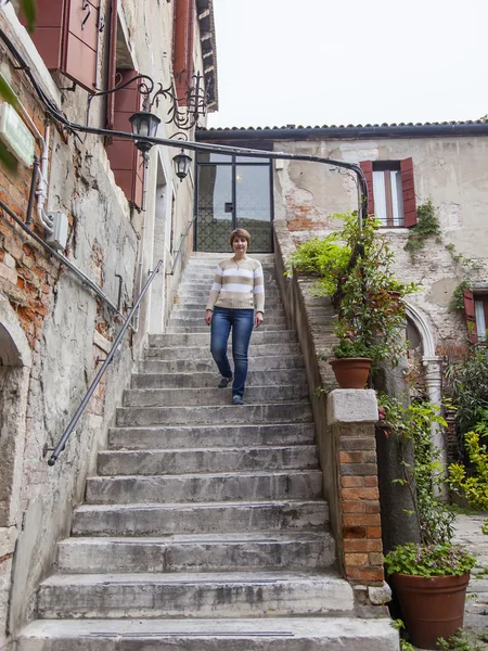 VENICE, ITÁLIA - em 1 de maio de 2015. A mulher desce em uma escada de pedra velha — Fotografia de Stock