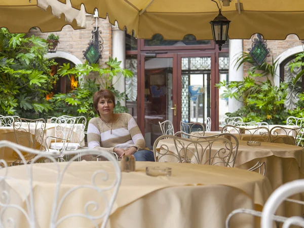 VENICE, ITÁLIA - em 1 de maio de 2015. A mulher senta-se em uma pequena mesa de café de verão — Fotografia de Stock