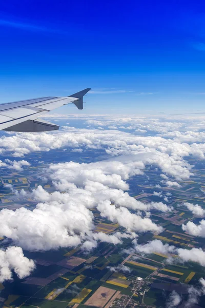 Αεροπλάνο θέα από το παράθυρο σε γραφικό τοπίο με άσπρα σύννεφα — Φωτογραφία Αρχείου