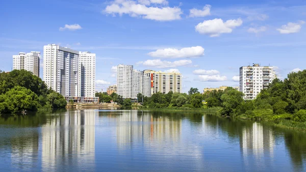 PUSHKINO, RUSSIA - on JUNE,18, 2015. River Serebryanka. New multystoried houses and its reflection in the water