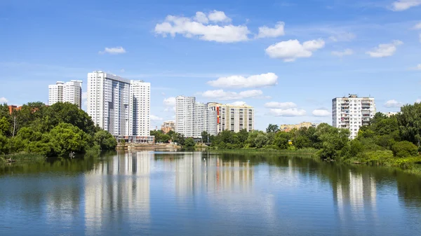 PUSHKINO, RUSIA - el 18 de junio de 2015. Río Serebryanka. Nuevas casas de varios pisos y su reflejo en el agua — Foto de Stock