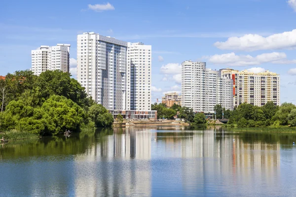 PUSHKINO, RUSIA - el 18 de junio de 2015. Río Serebryanka. Nuevas casas de varios pisos y su reflejo en el agua — Foto de Stock