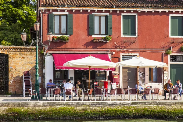 VENICE, ITALY - på APRIL 30, 2015. Folk hviler seg og spiser på sommerkafeen på bredden av kanalen – stockfoto