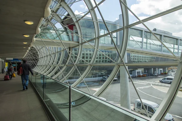 PARÍS, FRANCIA - 5 DE MAYO DE 2015. El aeropuerto internacional Charles de Gaulle, los pasajeros van desde el avión en el acristalamiento en la galería a la sala de una llegada . —  Fotos de Stock