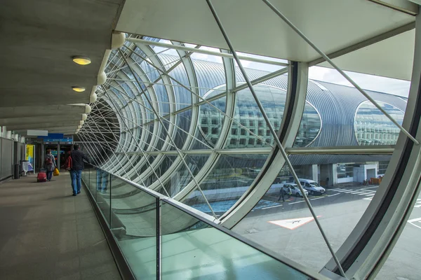 PARIS, FRANÇA - em 5 de maio de 2015. O aeroporto internacional Charles de Gaulle, os passageiros vão do avião em vidros na galeria ao corredor de uma chegada . — Fotografia de Stock