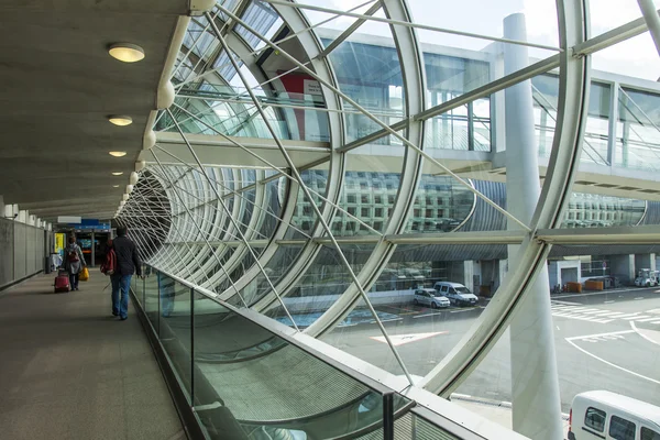 Paris, Frankrijk - op 5 mei 2015. de internationale luchthaven charles de gaulle, passagiers gaan van het vliegtuig op geglazuurde op galerij naar de zaal van een aankomst. — Stockfoto