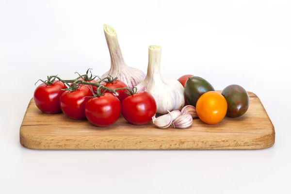 Спелые помидоры различных сортов и свежий чеснок — стоковое фото
