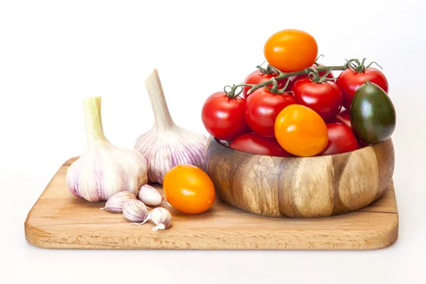 Rijpe tomaten van verschillende rangen en verse knoflook — Stockfoto