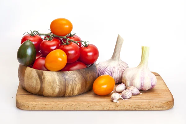 Ripe tomatoes of various grades and fresh garlic — Stock Photo, Image