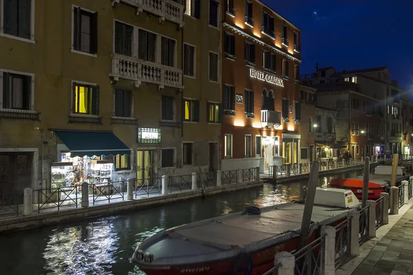 VENECIA, ITALIA - el 2 de mayo de 2015. Vista urbana nocturna. El canal y el terraplén, las lámparas y su reflejo en el agua — Foto de Stock