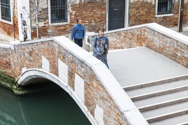 VENICE, ITÁLIA - em 3 de maio de 2015. A ponte com passos através do canal de rua, a vista superior de uma janela de casa na margem do canal — Fotografia de Stock