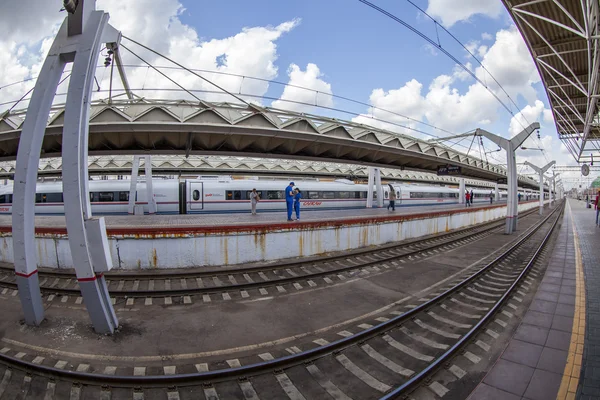 Moskau, russland, am 15. juli 2015. der moderne hochgeschwindigkeitszug sapsan in der nähe des bahnsteigs des bahnhofs leningrad, passagiere gehen auf den bahnsteig, fisheye view. — Stockfoto