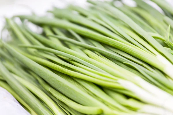Bunches of green onions on a market counter — Stock Photo, Image