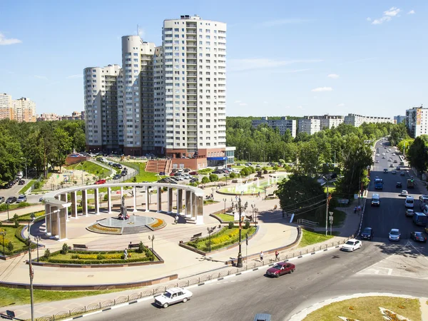 PUSHKINO, RUSSIA - on JUNE 13, 2015. City landscape in the summer afternoon. A memorial in the downtown and multystoried new building — Stock Photo, Image